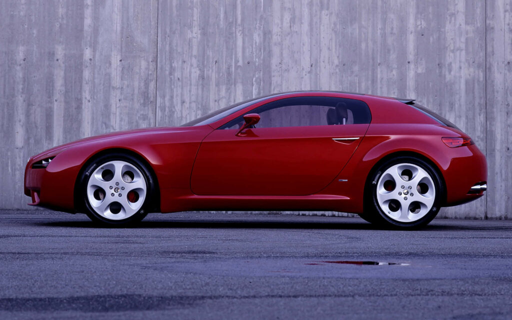 Red Alfa Romeo Brera sports car with sleek curves against modern concrete backdrop wallpaper