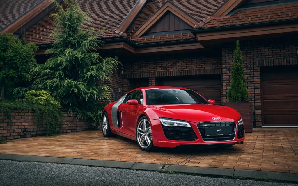 Sleek Red Audi R8 Wallpaper: Luxury Against Rustic Brick Home
