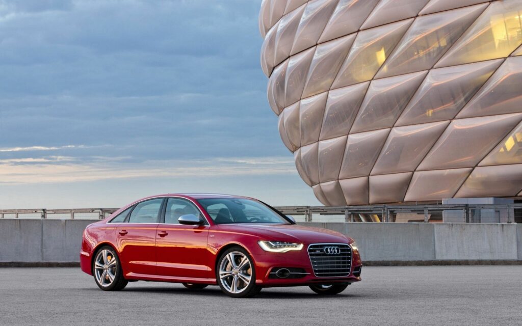 Sleek Red Audi S6 Sedan Side View with Modern Architectural Background Wallpaper