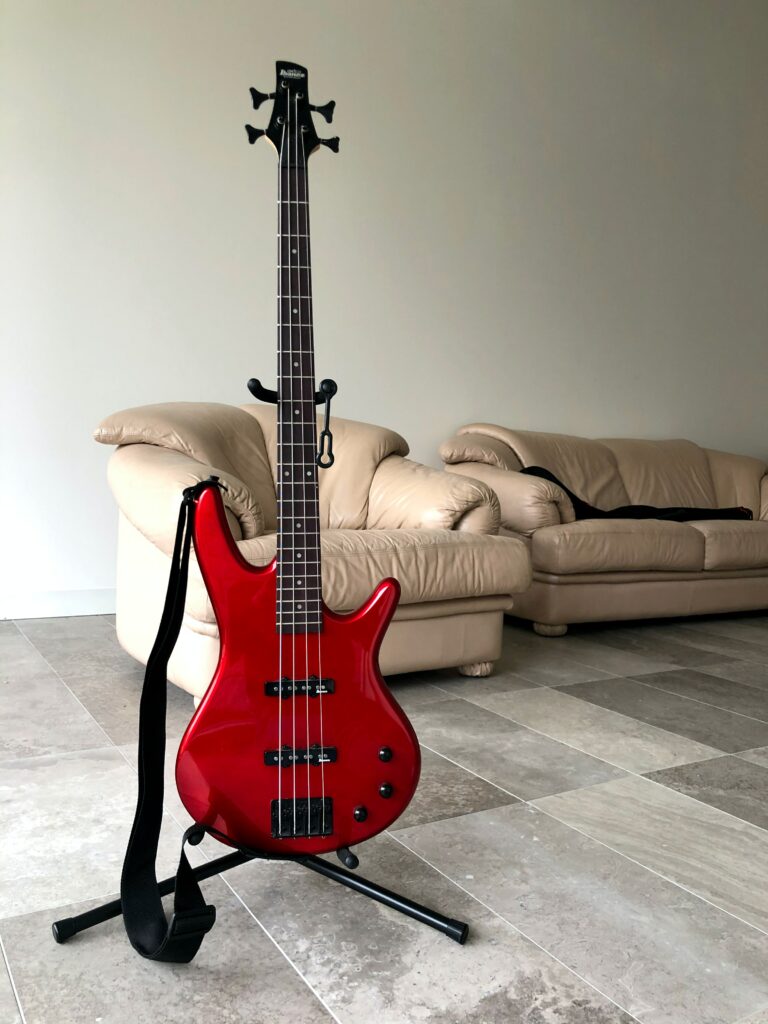 Sleek Red Bass Guitar Wallpaper in Minimalist Interior Setting