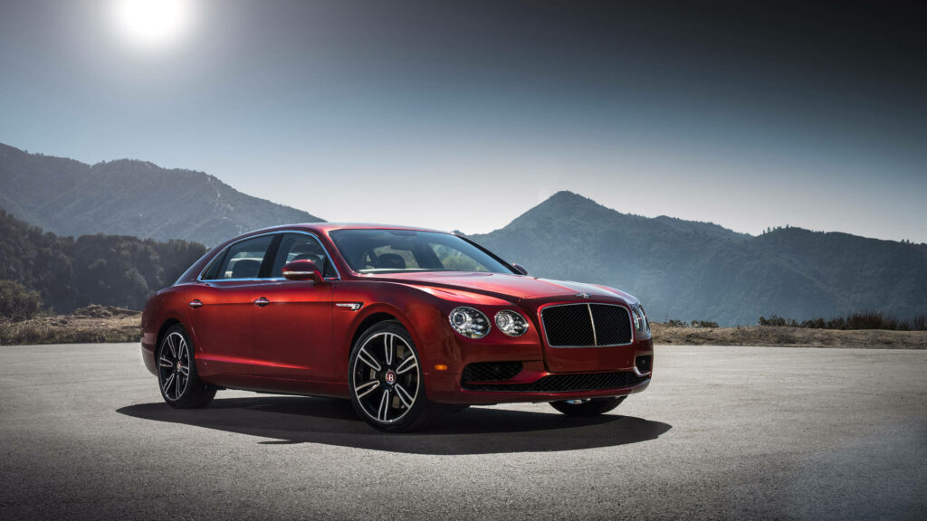 Mountain Majesty: Red Bentley Flying Spur Conquers Nature's Beauty Wallpaper