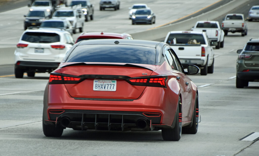 Sleek Red Car on Busy Highway - Dynamic Automotive Wallpaper