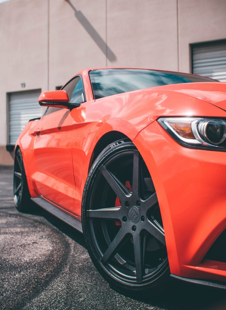 Sleek Red Car Wallpaper: Sporty Design in Urban Background