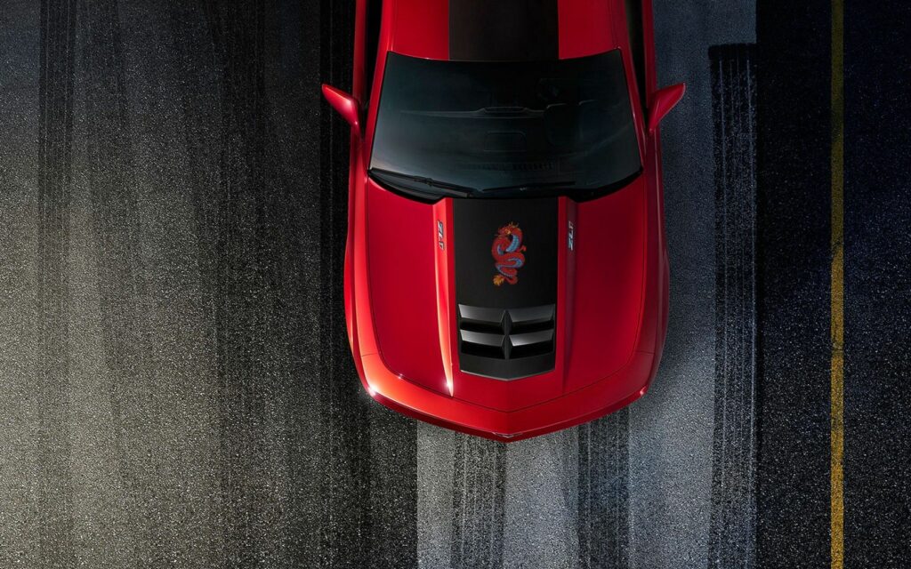 Top-Down View of Modified Red Chevrolet Camaro on Textured Road Wallpaper