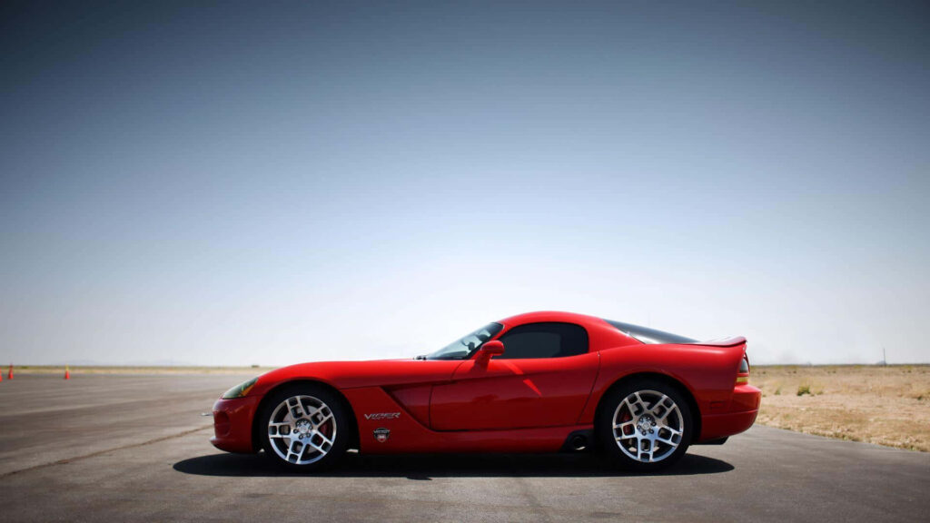 Red Dodge Viper side view parked on open road clear sky aerodynamic sporty car wallpaper background