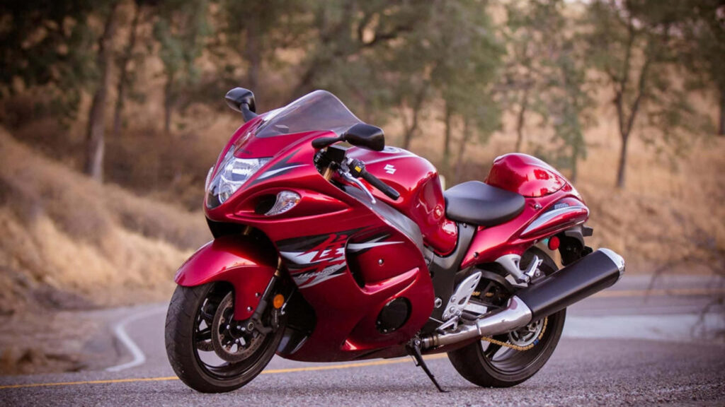 Sleek Red Motorcycle Wallpaper: Dynamic Curves in Nature's Glow