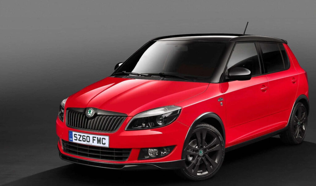 Sleek Red Skoda Fabia Wallpaper in Modern Urban Setting