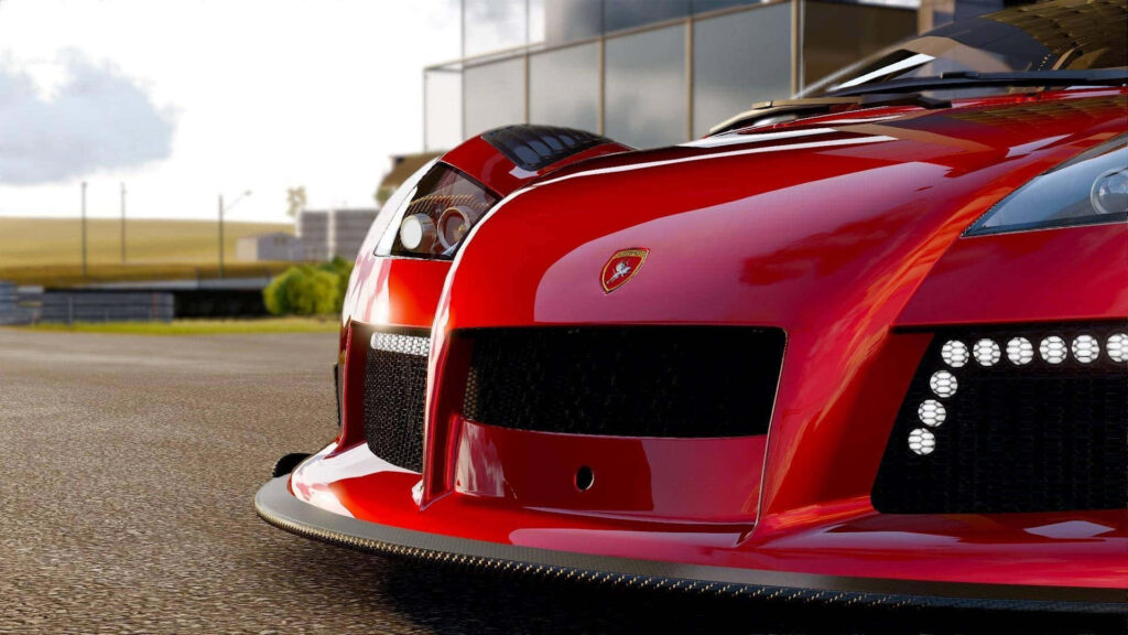 Red sports car with sleek design parked by modern building reflecting light on polished surface Wallpaper