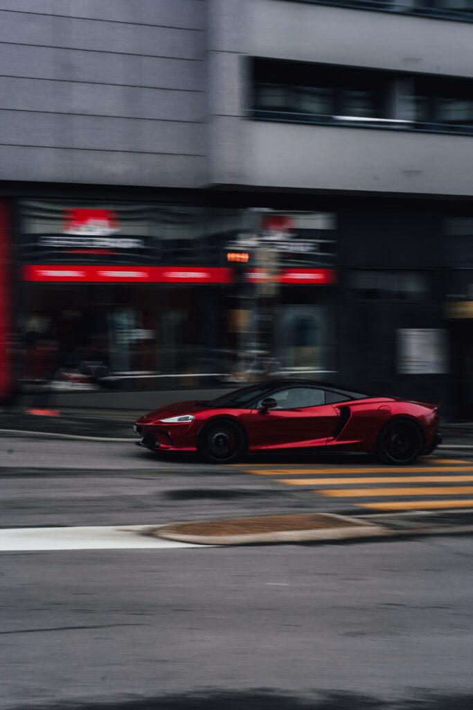 Dynamic Wallpaper: Red Sports Car Racing Through Urban Streets