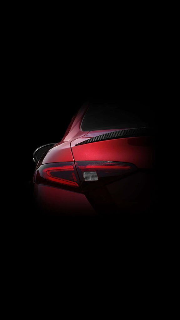 Close-up of powerful red car rear with sleek curves and modern design on black background wallpaper