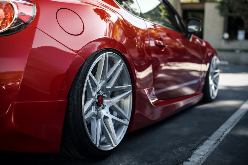 Sleek Red Sports Car Wallpaper: Shiny Body & Alloy Wheels