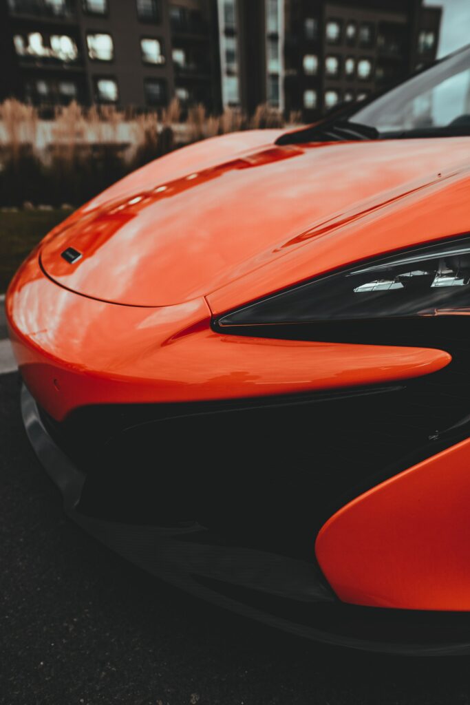 Sleek Red Sports Car Wallpaper: Aerodynamic Design in Urban Setting