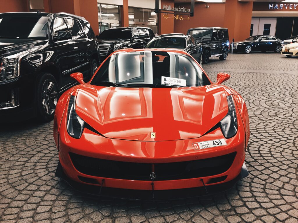 Sleek Red Sports Car Wallpaper in Luxurious Setting on Cobblestone
