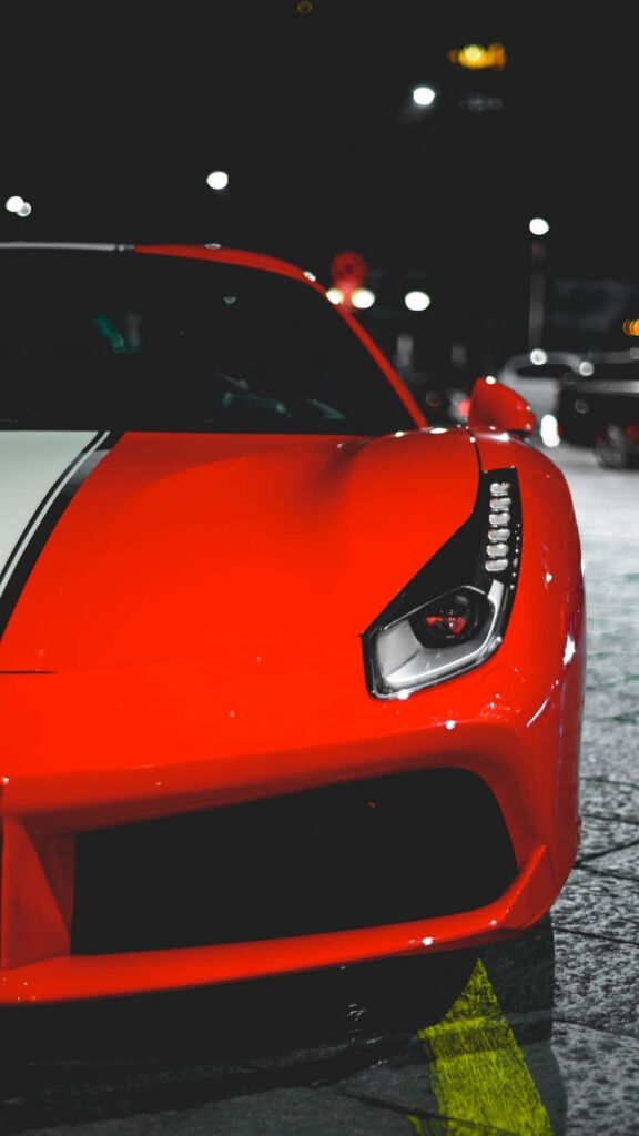 Red sports car iPhone wallpaper with sleek design and night city skyline background for style