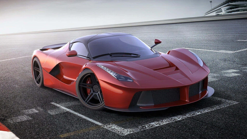 Sleek red sports car on sunlit racetrack showcasing aerodynamic design and glossy finish wallpaper