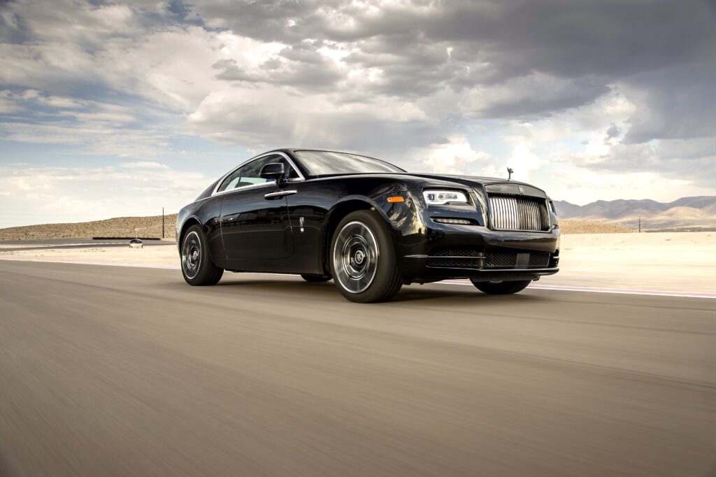 Sleek Rolls-Royce Wraith in Motion Amidst Desert Landscape Wallpaper
