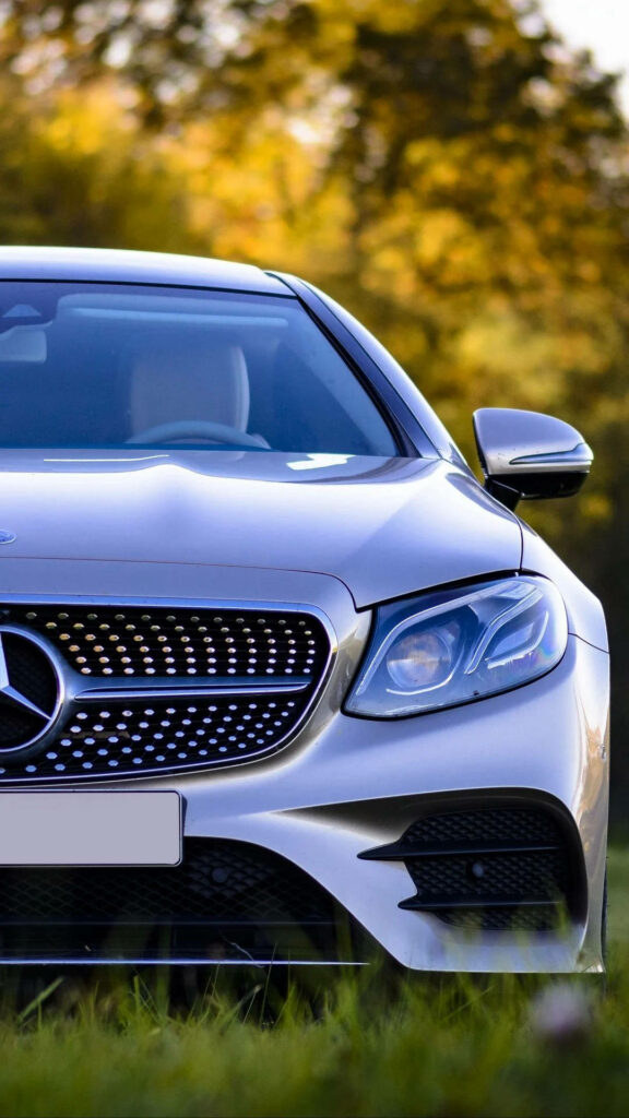 Sleek Silver Mercedes-Benz E-Class Wallpaper with Golden Glow Background