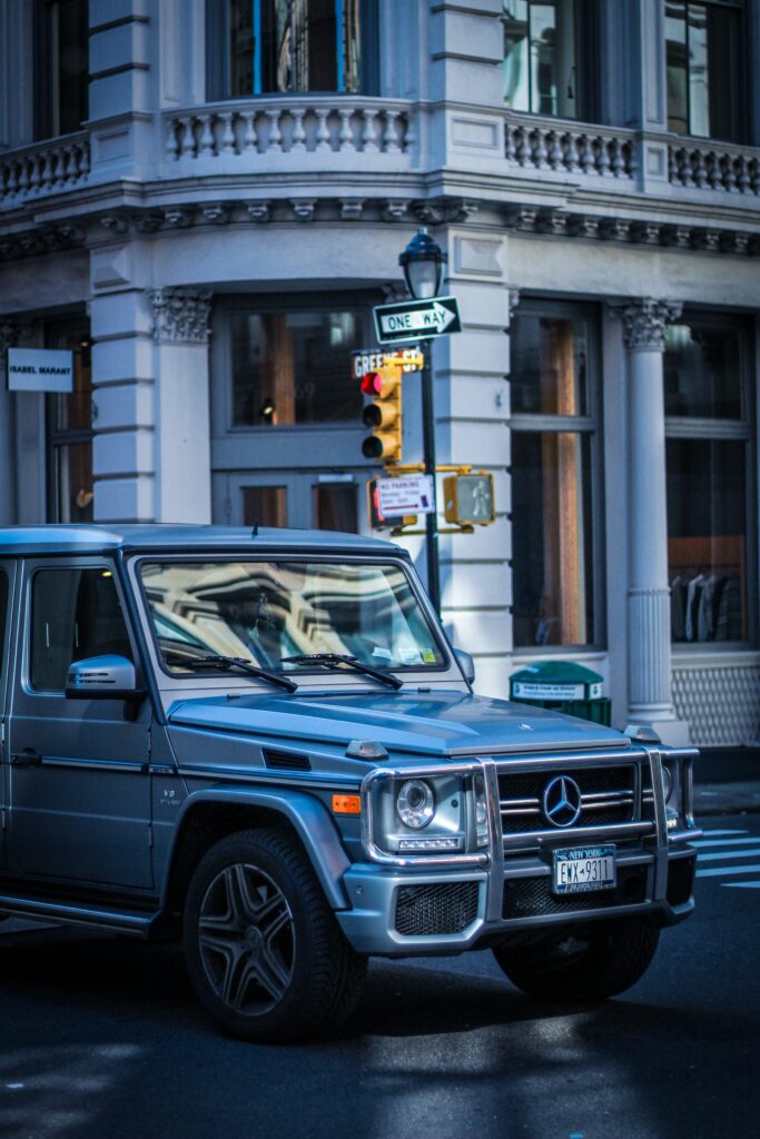 Sleek Silver Mercedes G-Class SUV in Bustling City Background Wallpaper