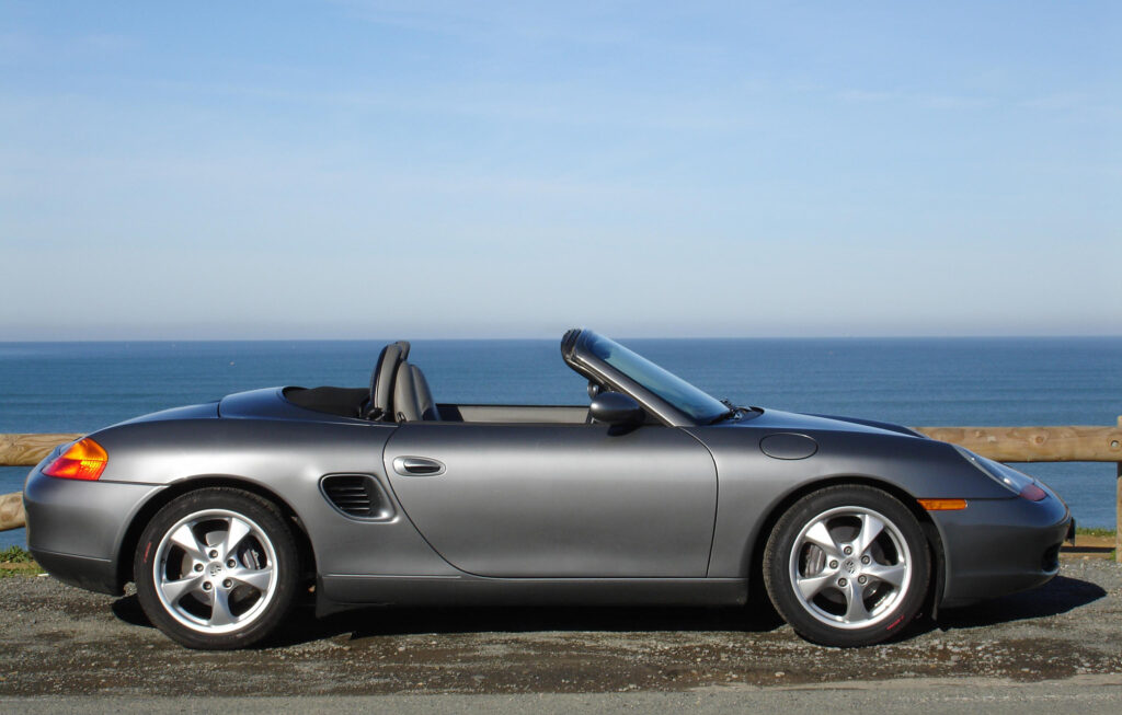 Elegant Silver Porsche Boxster Convertible with Scenic Ocean Background Wallpaper