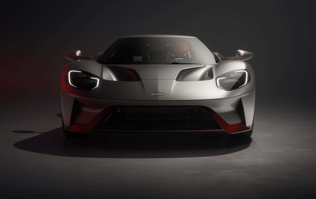 Sleek silver sports car with aerodynamic design and aggressive front profile in dramatic light Wallpaper