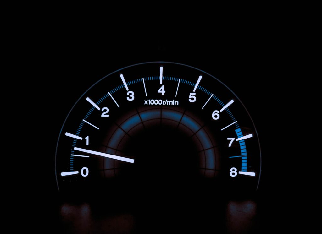 Illuminated Speedometer Wallpaper: Sleek Dark Background Design