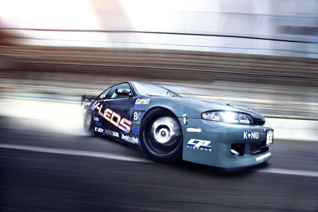 Sleek sports car speeding on urban road showcasing dynamic design and racing performance wallpaper