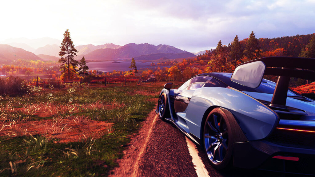 Sleek sports car racing on countryside road with autumn trees mountains and sunset in Forza 4 Wallpaper