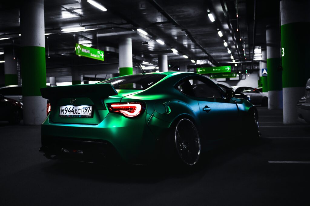 Sleek Tuned Sports Car in Urban Garage: Glossy Design & Gritty Vibe Wallpaper