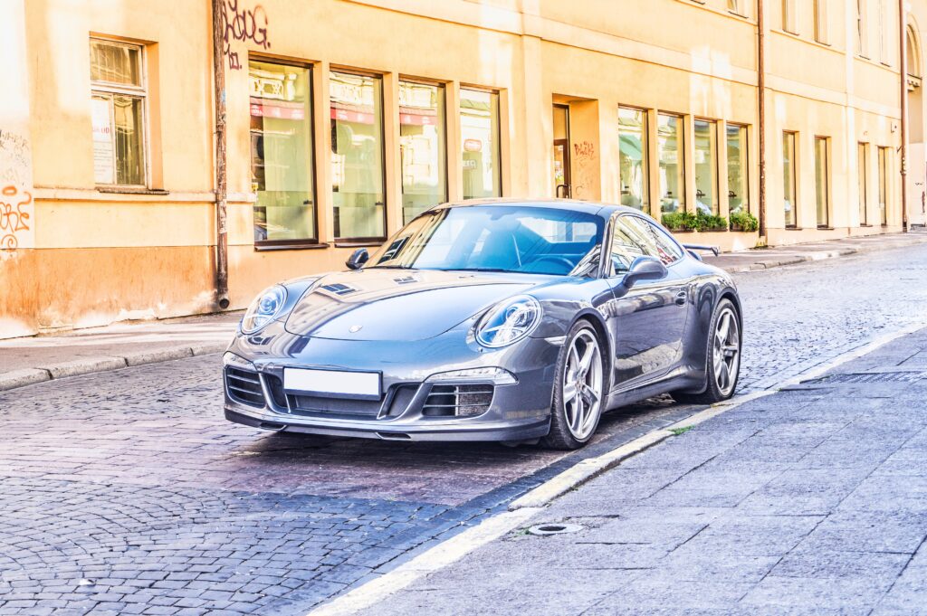 Sleek Front View Sports Car Wallpaper on Cobblestone Street