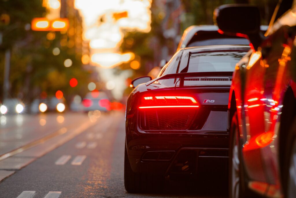 Sleek Sports Car Wallpaper: Gleaming Headlight in Traffic Motion