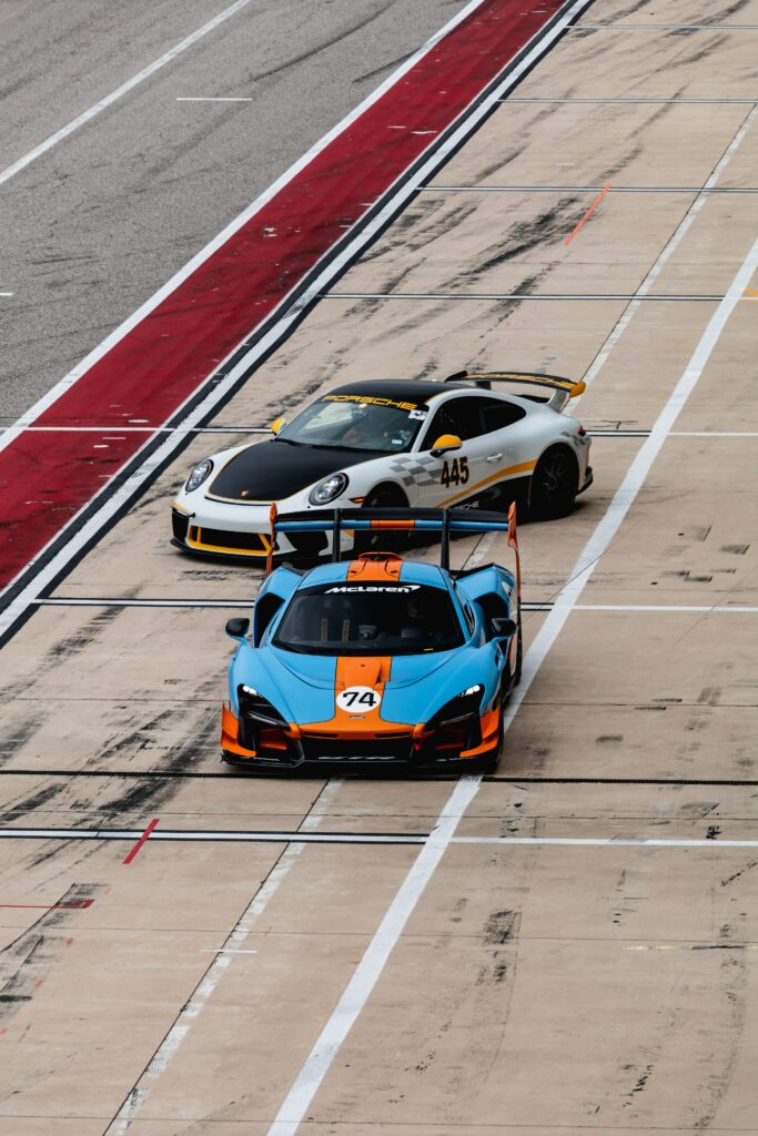 Aerial Wallpaper of Sleek Sports Cars on Racetrack - Dynamic Colors
