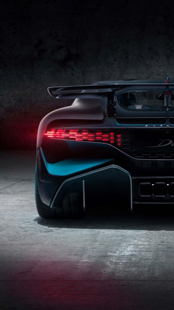 Back view of high-performance supercar with sleek aerodynamic design and bold rear lights on concrete Wallpaper