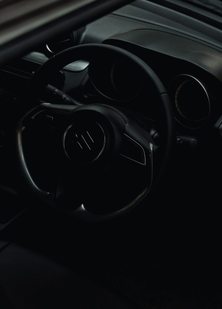 Sleek Suzuki Car Interior: Elegant Steering Wheel in Dim Light Wallpaper
