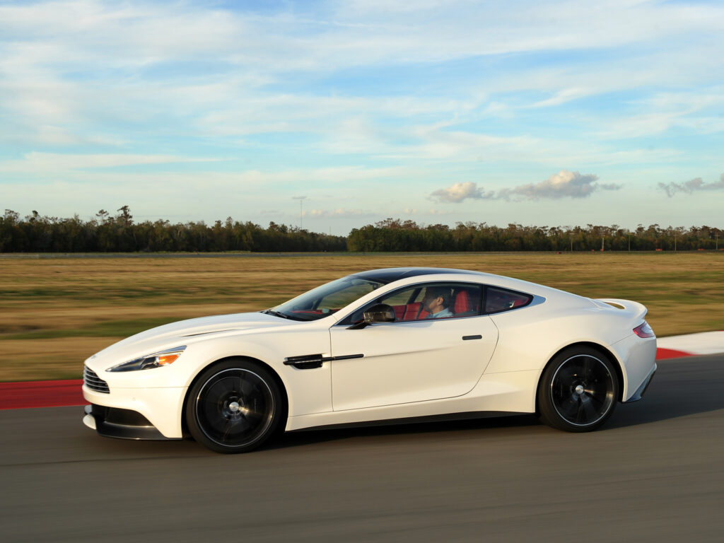 Elegant White Aston Martin Vanquish in Dynamic Scenic Background Wallpaper
