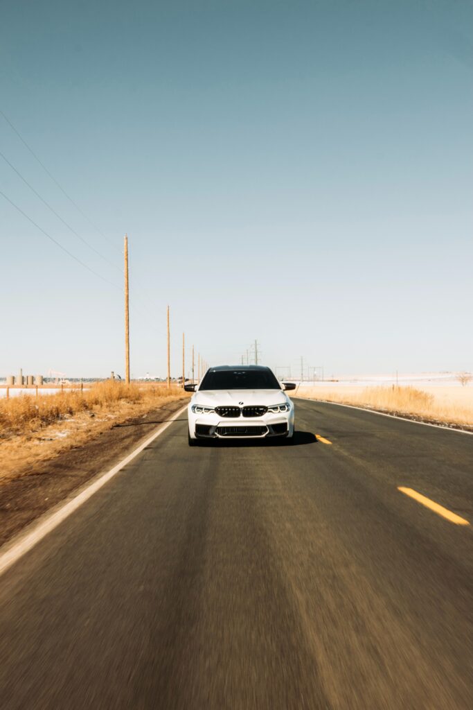 White BMW on Open Road: Adventure Wallpaper Under Clear Blue Sky