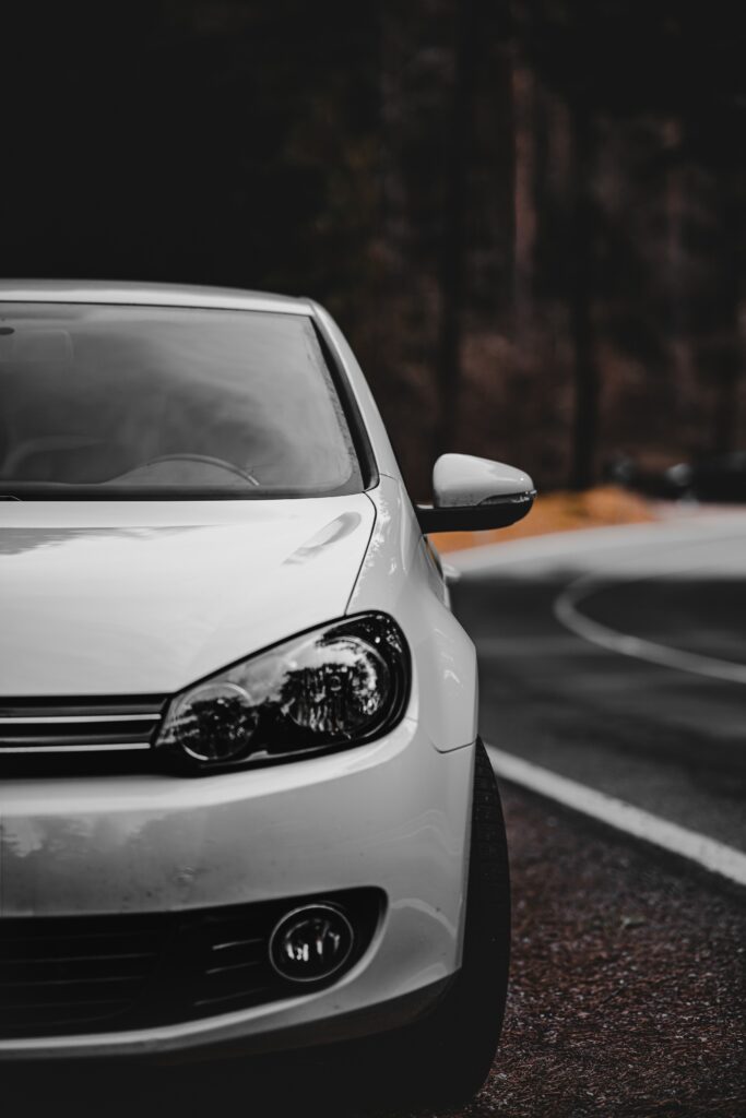 White Car Front View: Sleek Headlights on Scenic Winding Road Wallpaper