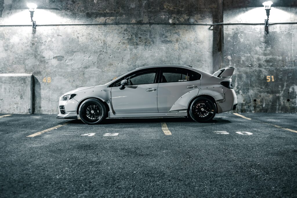 Sleek White Car Side View Wallpaper: Sporty Design in Urban Setting