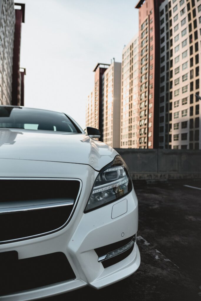 Sleek White Car Wallpaper Against Modern Urban Skyline