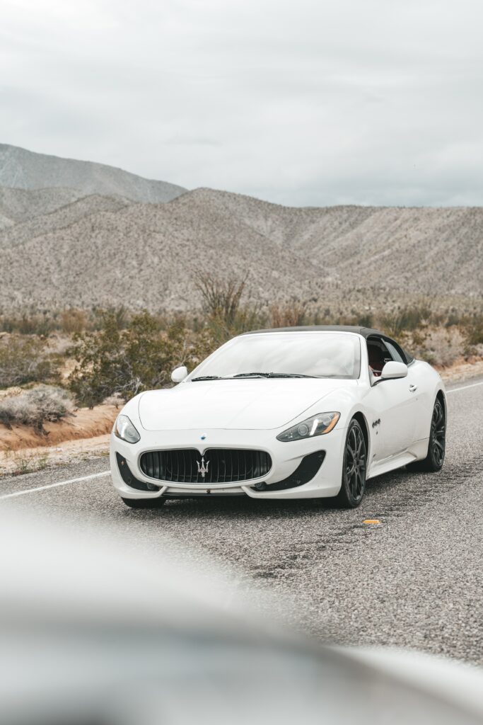 Sleek White Maserati GranCabrio Against Rugged Mountain Backdrop Wallpaper