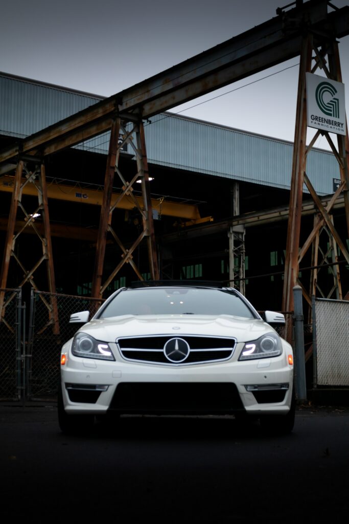 Sleek White Mercedes Front View Wallpaper with Industrial Background