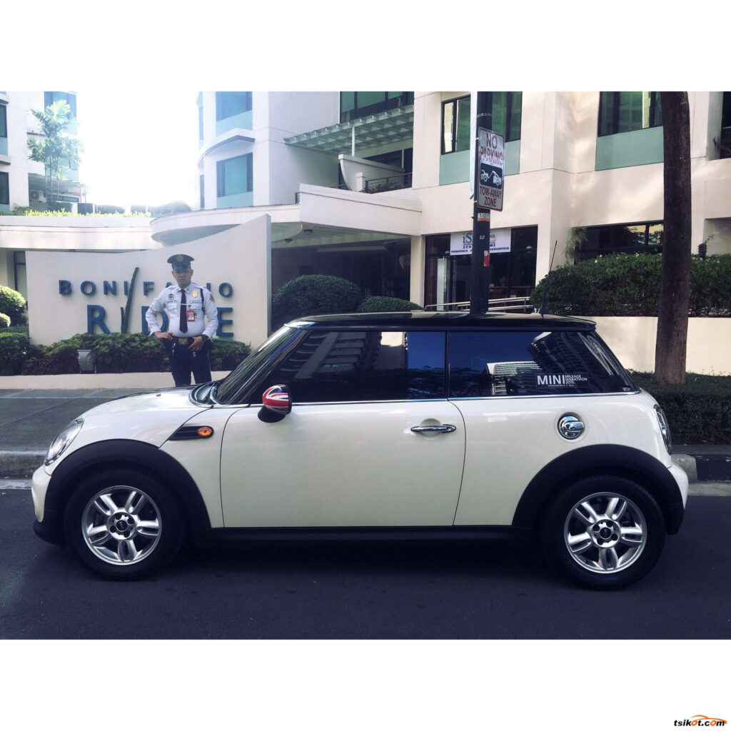 Sleek White Mini Cooper Parked by Modern Architecture & Security Guard Wallpaper