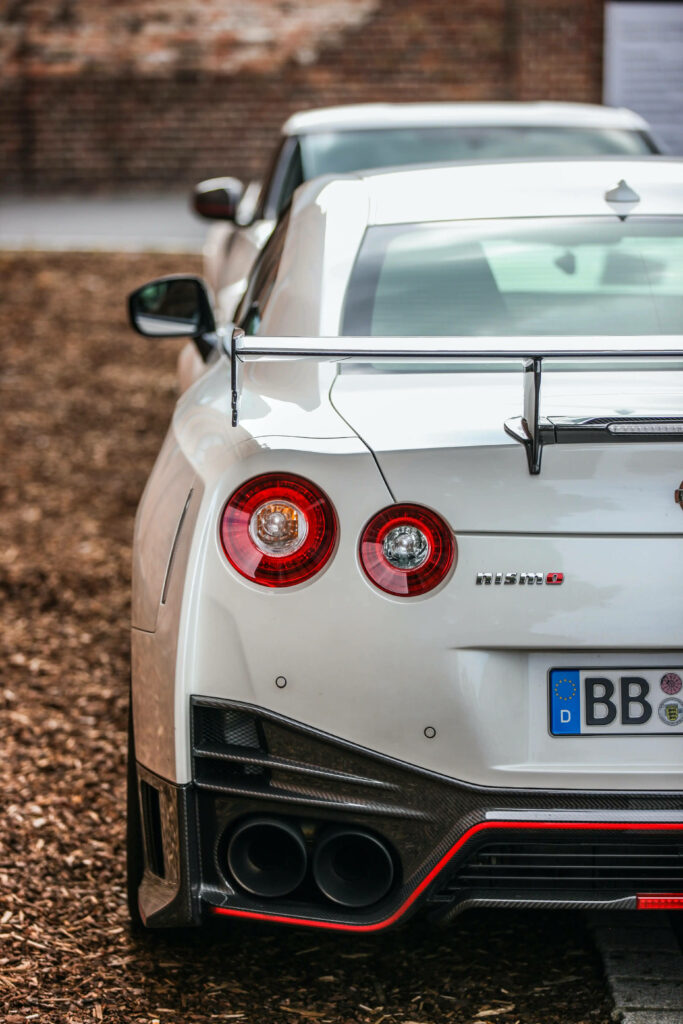 White Nissan Nismo GT-R Wallpaper: Sporty Design with Rustic Backdrop