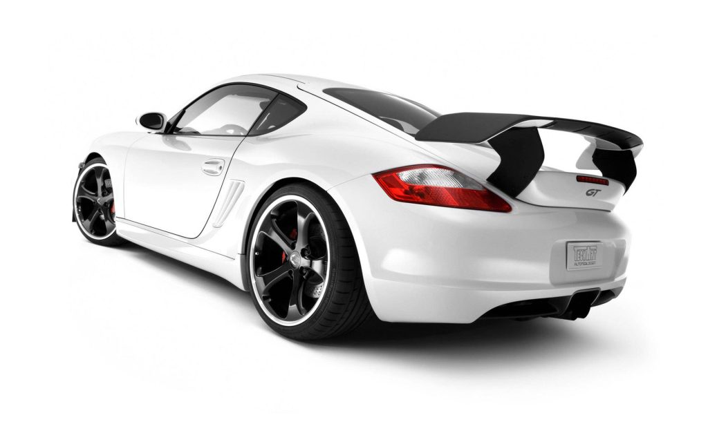 White Porsche Cayman rear view with black TechArt spoiler and custom wheels studio wallpaper