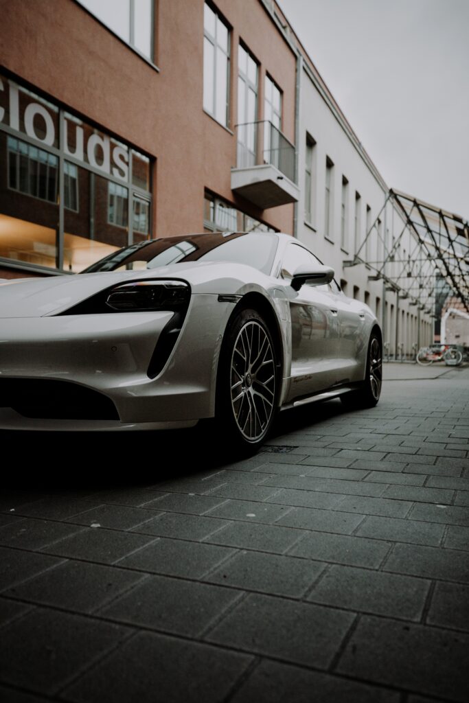 Sleek White Porsche in Urban Setting: Modern Architecture Wallpaper