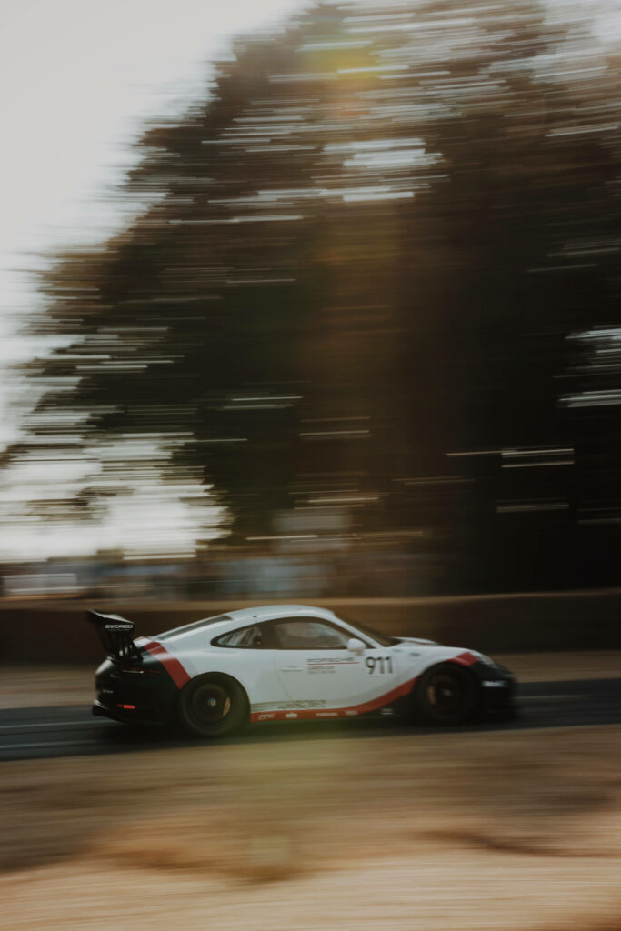 White racecar speeding on track dynamic motion blur thrilling racing iPhone wallpaper background