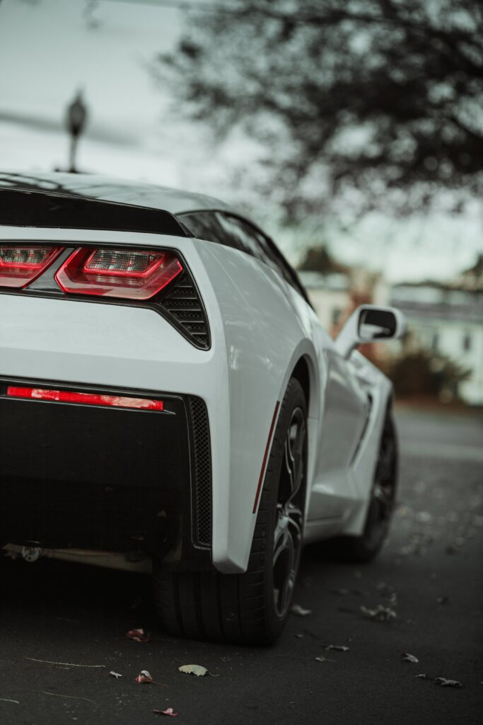 Rear View of Sleek White Sports Car with Blurred Road Background Wallpaper