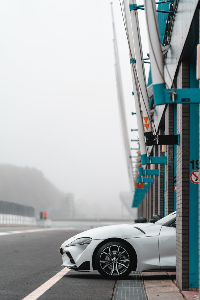 Sleek White Sports Car in Racing Pit Lane - 4000x6000 Wallpaper