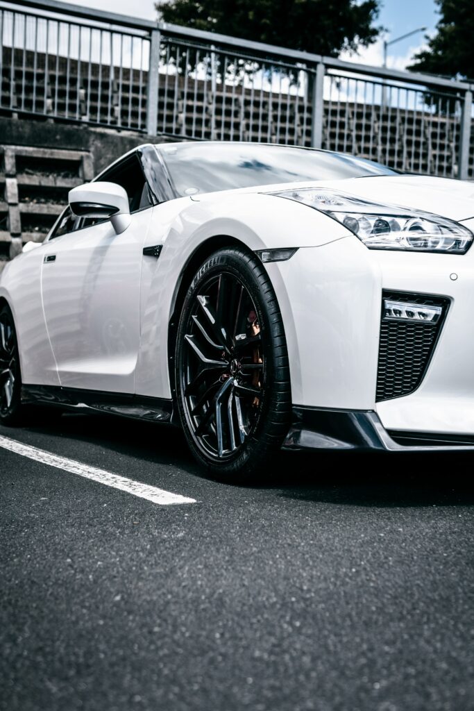 Modern White Sports Car with Black Wheels in Urban Setting Wallpaper