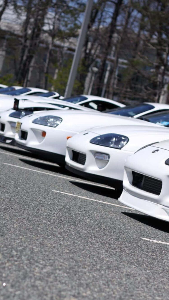 Lineup of sleek white sports cars parked side by side for stylish modern wallpaper background