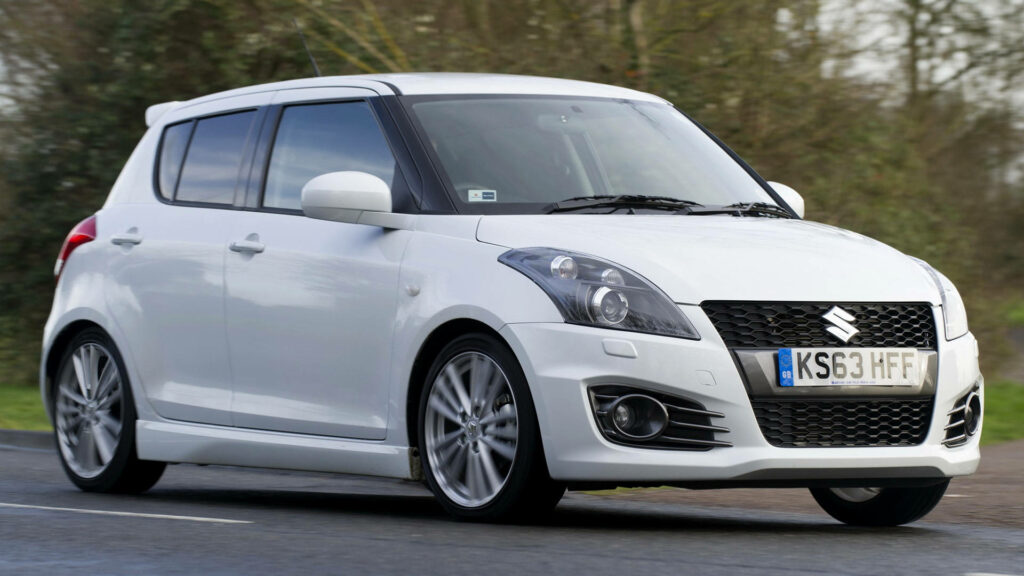 Sleek Suzuki Swift Wallpaper: Sporty Car on Smooth Road Background